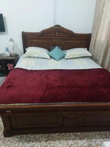 阿布扎比Furnished bedroom near Abu Dhabi Corniche的一张带两个枕头的木床