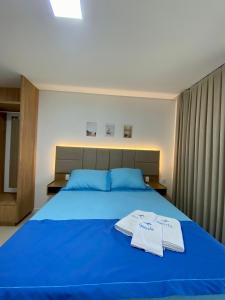 特赖里Refúgio em Condomínio- Flecheiras的一间卧室配有蓝色的床和2条毛巾