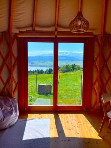 SzlembarkWoda Góry Las - glamping CAŁOROCZNY的客房设有一个享有田野景致的窗户。