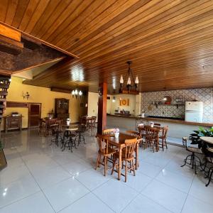 康赛瓦托利亚Pousada das Flores的餐厅设有木制天花板和桌椅