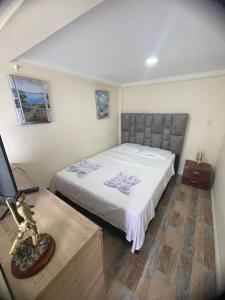 马尼萨莱斯Ecohotel Java的卧室配有一张白色的大床和一张桌子
