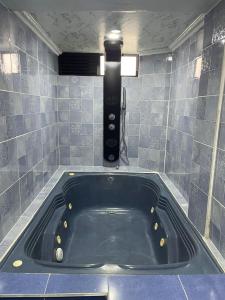 马尼萨莱斯Ecohotel Java的浴室设有浴缸,铺有蓝色瓷砖。