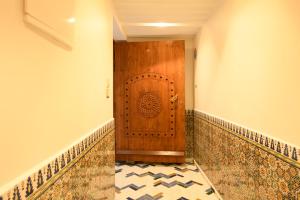 拉巴特Luxurious Riad Center Rabat Dar Al Jeld的走廊设有木门,铺有瓷砖地板