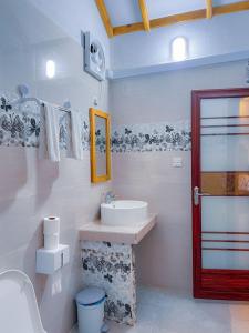 图杜Thoddoo Haisha inn, Maldives的白色的浴室设有水槽和镜子