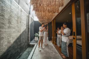 坎古Canggu Cabana Resort By Ini Vie Hospitality的一群人在走廊上拍照