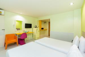 芭堤雅市中心贝拉快捷酒店的一间卧室配有两张床和一张带电脑的书桌