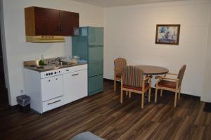 BassanoA1 Motel And Campground的厨房配有桌子、水槽和桌椅