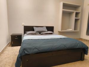 PayyannūrComfort INN的一间卧室配有一张大床和木制床头板