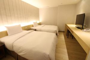 高雄简单生活商旅的酒店客房设有两张床和一台平面电视。