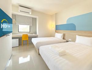 拉差汶里Hop Inn Ratchaburi的酒店客房配有两张床和一张书桌