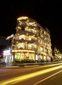 萨帕Tropical Paradise Sapa Hotel & Coffee的夜空在城市街道上被点燃的建筑物