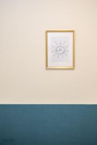 海法Domus Bat Galim Hotel的白色墙上的太阳照片
