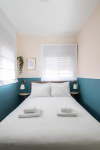 海法Domus Bat Galim Hotel的卧室配有一张白色大床和两条毛巾