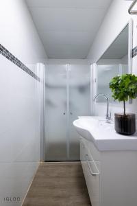 海法Domus Bat Galim Hotel的白色的浴室设有水槽和淋浴。