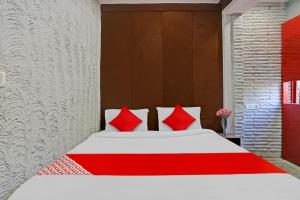 新德里Flagship Kashish Residency的一间卧室配有红色枕头的床