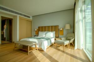 阿吉曼Zoya Health & Wellbeing Resort的卧室配有1张床、1张桌子和1把椅子