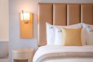 阿吉曼Zoya Health & Wellbeing Resort的配有白色枕头的床的酒店客房