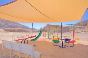 瓦迪拉姆Bilal luxury camp的沙漠中的游乐场,配有黄色雨伞