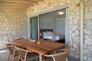 Ayios TheodhorosElya Beach Luxury Suites的一间带木桌的用餐室和一间卧室