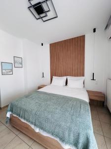 欧拉努波利斯斐罗克斯尼娜酒店的一间卧室配有一张带绿毯的大床