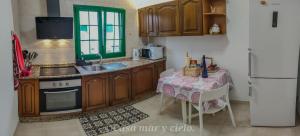 普拉亚布兰卡Casa mar y cielo的厨房配有桌子、水槽和冰箱