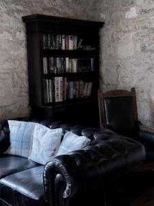 斯特明斯特牛顿The Crown at Marnhull的黑色皮沙发和书架