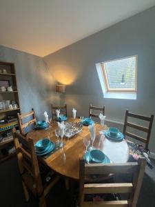 格拉斯哥Pheasant lodge - Balmaha 3 bed的一张带蓝盘和玻璃杯的餐桌