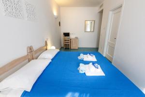维拉西米乌斯Villa Tre Mari的一间卧室配有蓝色的床和毛巾