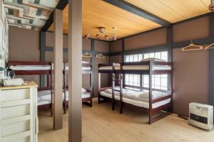 汤泽町The HOTEL YUZAWA STARDUST的客房设有三张双层床和一张书桌。