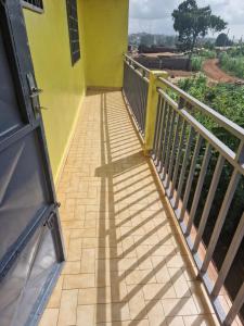 BafoussamBel Appartement meublé à Bafoussam的黄色建筑的阳台,带有栏杆