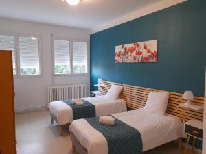 蒙托邦Centre Louis Ormières的配有两张床铺的蓝色墙壁和窗户