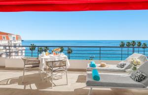 戛纳雄伟戛纳巴里耶尔酒店的一个带桌椅的海景阳台