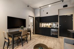 奥斯陆The APARTMENTS Company- Frogner的厨房以及带黑色桌椅的用餐室。