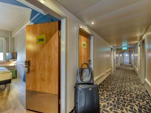 卢塞恩卢塞恩城宜必思快捷酒店的走廊上设有门和手提箱
