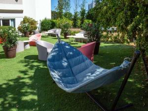 布尔日布尔吉诺富特酒店的庭院里设有一张蓝色秋千,配有桌椅
