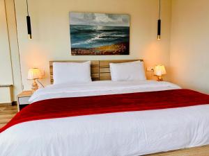 伊斯兰堡Centaurus Apartment Three Bed的一间卧室配有一张带两盏灯的大型白色床。