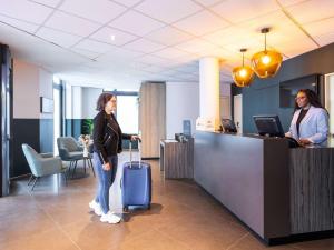 布鲁塞尔宜必思酒店风格布鲁塞尔中心史蒂芬妮的一位带着手提箱站在办公室里的女人