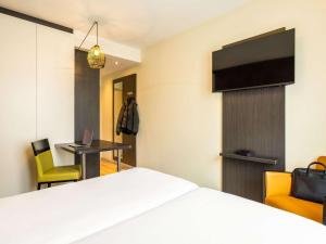布鲁塞尔宜必思酒店风格布鲁塞尔中心史蒂芬妮的酒店客房设有一张床、一张书桌和一台电视机。
