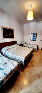 巴里Casa Piacquadio的一间卧室配有三张床和一盏灯