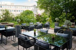 柏林NH酒店柏灵选帝侯大街店的一座配有桌椅的庭院和一座建筑