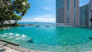 芭堤雅市中心芭堤雅假日酒店的一个蓝色的海水游泳池,高高的建筑