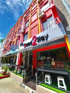 马六甲Good2Stay Budget Hotel的建筑前有两把凳子的商店
