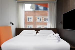 伦敦StowAway Waterloo的卧室配有一张大白色床和窗户