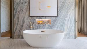 迪拜Jumeirah Al Naseem Dubai的浴室配有白色浴缸,浴室设有墙壁