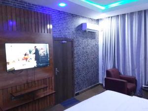 IladoExclusive mansion lekki phase 1的砖墙上配有电视的房间