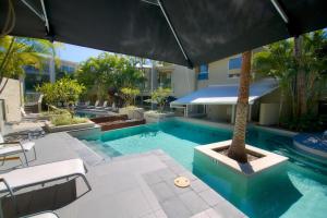 卡巴雷塔海滩卡巴雷塔海滩酒店的一个带棕榈树和遮阳伞的游泳池
