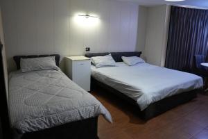 伊尔比德Omayah hotel irbid的一间卧室设有两张床,墙上配有一盏灯。