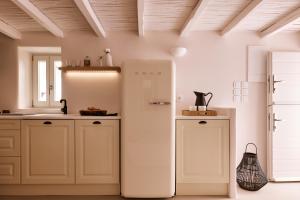 特里皮蒂Windmill Karamitsos since 1859的厨房配有白色的冰箱,厨房配有白色的橱柜
