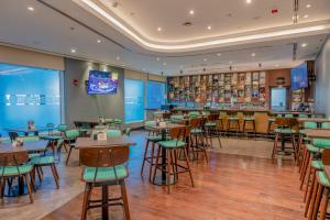 阿布扎比Premier Inn Abu Dhabi Airport Business Park的一间带桌椅的餐厅和一间酒吧
