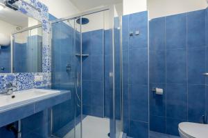 那不勒斯Napolit'amo Hotel Medina的蓝色瓷砖浴室设有水槽和淋浴